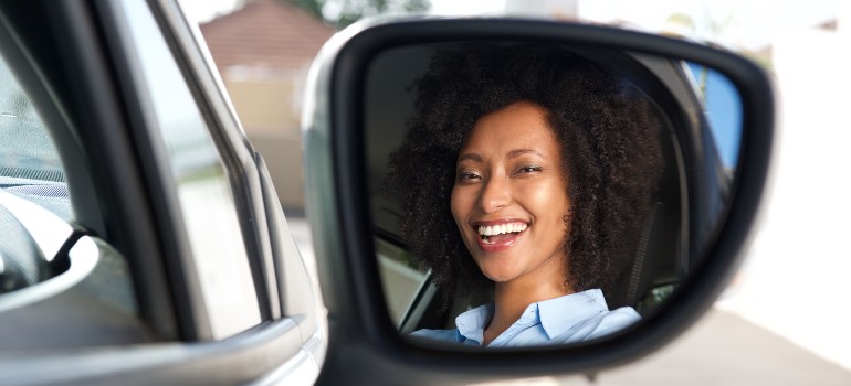 Girl looking in car mirror