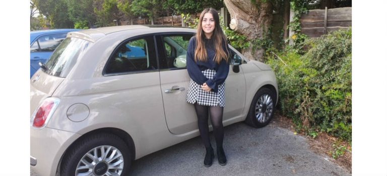 happy girl stood next to car 